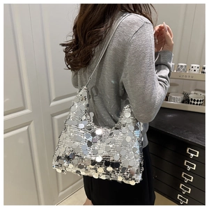 Sac hobo à paillettes argentées porté épaule montrant taille et reflets chic