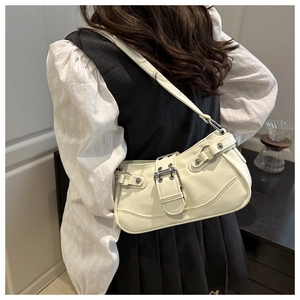 Detail view of cream white PU leather shoulder bag with punk rivets and belt buckles