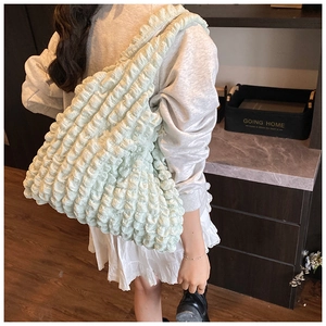 Lifestyle shot of large popcorn texture tote bag in mint green worn on shoulder