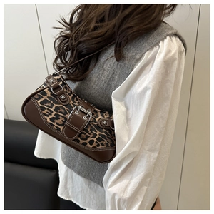 Detail of leopard print shoulder bag with silver belt buckle and rivet accents