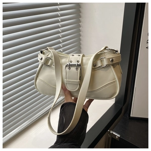 Detail of white PU leather shoulder bag featuring wide strap buckle and silver metal eyelets