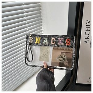 Close-up of leopard print transparent PVC toiletry bag with colorful SNACKS letter embroidery
