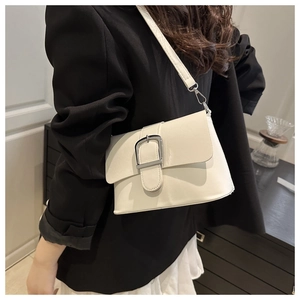 Mannequin portant un sac bandoulière blanc crème avec grande boucle argentée et rabat chic