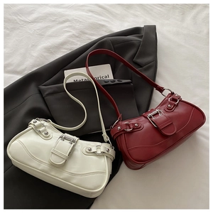 Close-up of retro baguette bags in off-white and deep red with silver buckles