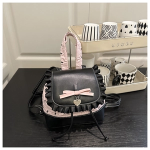 Close-up of pink bow and silver heart pendant on ballet style bicolor backpack