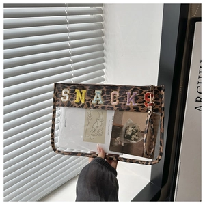 Detail of leopard print PVC toiletry bag with SNACKS embroidery and wristlet strap
