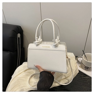 Detail of white PU leather tote with unique knotted rope handle and fashion gold lettering