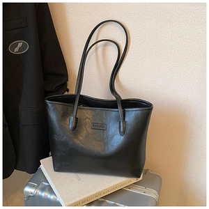 Detail view of black faux leather tote with litchi texture and fashion embossing