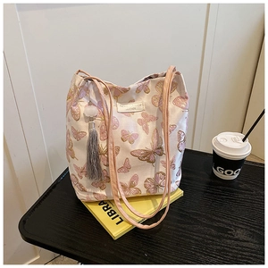 Detailed embroidery of pink butterflies and tassel on this cream-colored tote bag