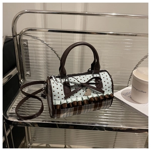 Detail of sweet bow, lace trim, and star pattern on this trendy cylindrical handbag