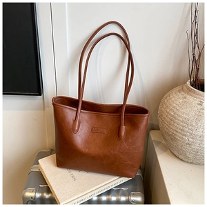 Close-up of vintage brown tote bag showing subtle leather texture and fashion embossing