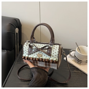 Detailed view of sweet bow decor and ruffle lace edge on a polka dot handbag
