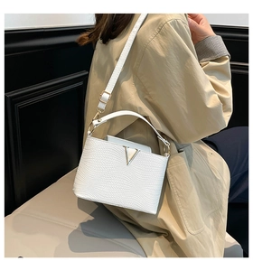 Détail du sac bandoulière tressé blanc avec logo V doré et bandoulière en cuir