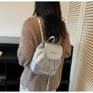 Detail shot of a silver mini backpack with cartoon prints on a female model back