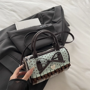 Blue Boston bag with star patterns, bow detail and ruffled hem on a stylish suit