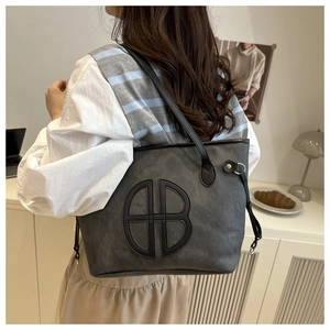 Detail of grey tote bag with HB logo on matte synthetic leather for office use