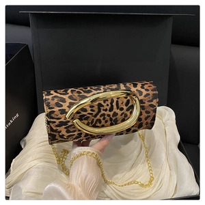 Detail of leopard print leather crossbody bag with elegant gold oval metal buckle and chain