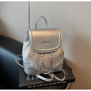 Detail of silver metallic backpack with orange cartoon print and chain decoration