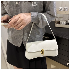 Détail du sac à main en cuir blanc avec texture litchi et fermoir en métal doré brillant