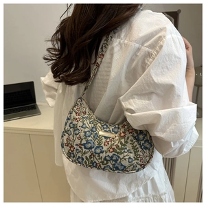 Detail of floral jacquard hobo bag showing the vintage pattern and golden metal plate