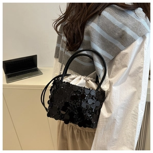 Detail of sequin bucket bag with drawstring satin lining and silver chain strap