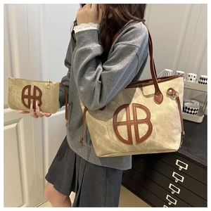 Detailed view of the large capacity tote bag and matching small pouch on a model