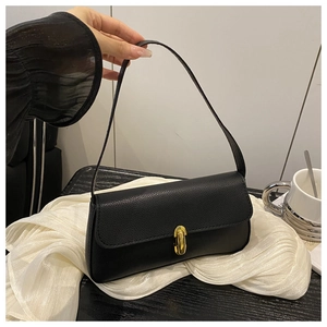 Détail du sac baguette en cuir grainé noir avec fermoir rotatif ovale doré brillant