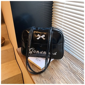 Close-up of black glossy PU leather bowling bag featuring white bow and embroidery