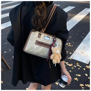Retro olive green canvas tote bag with brown leather trim and cute bear charm outdoors