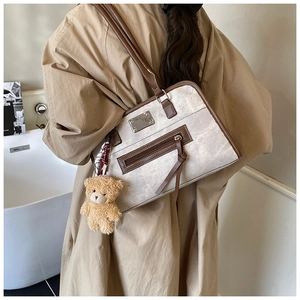 Détail du dos d'un grand sac cabas en toile rétro avec bordure en cuir marron et pendentif