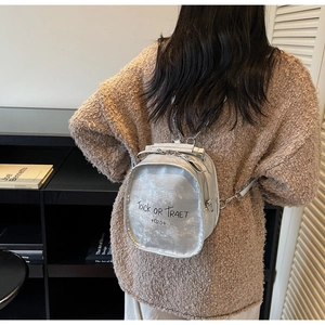 Detail of silver mini backpack featuring metallic crinkled texture and letter print