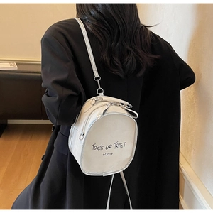 Detail of white mini backpack showing letter print and smooth faux leather texture