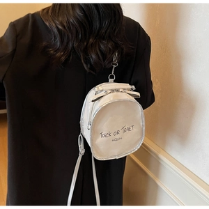 Detail view of the white mini backpack with decorative text and silver hardware