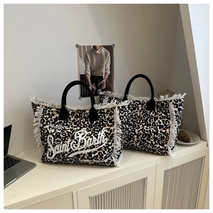 Detail of leopard print canvas tote bag featuring cream fringes and Saint Barth embroidery