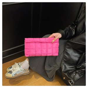 Detail of bright pink quilted clutch bag with fluffy texture and square stitch pattern