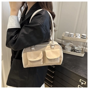 Detail of vintage suede shoulder bag with dual front flap pockets and slim straps