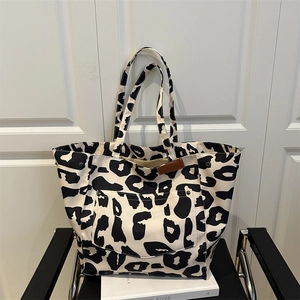 Grand sac cabas en nylon à motif léopard avec poche avant posé sur une chaise noire
