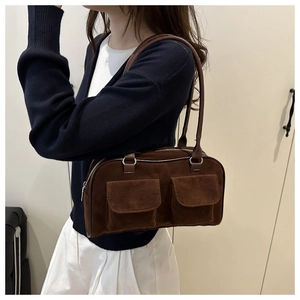 Detail of vintage dark brown suede tote featuring dual front pockets and shoulder straps