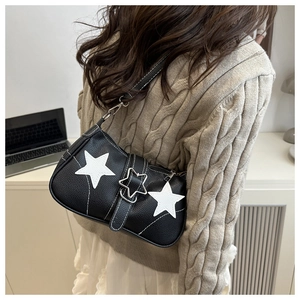 Detail view of a black star-embellished shoulder bag worn on a model back profile