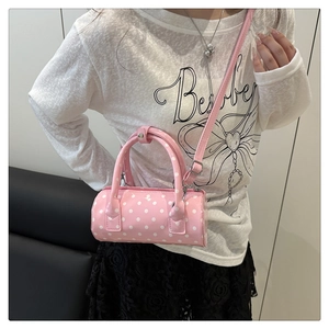 Polka dot pink barrel handbag styled with casual outfit for a trendy summer look