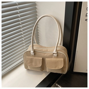 Detail view of the beige textile bowling bag with dual front pockets and long straps