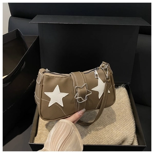 Detail of retro khakhi pebbled leather handbag with white star patches and metal buckle