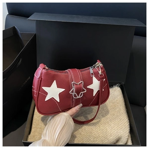 Detail of red pebbled leather shoulder bag featuring white star patches and silver buckle