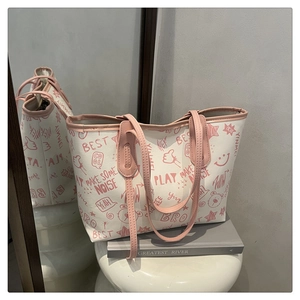 Detail view of large white tote bag with pink graffiti print and metallic mirror reflection