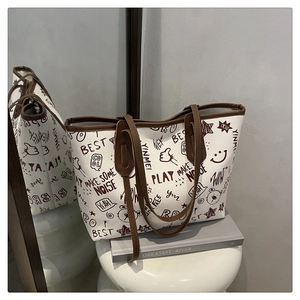 Detail view of large white tote bag with graffiti prints on a stylish display