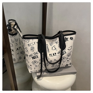 Detail of large white tote bag featuring black hand-drawn graffiti and cute doodles