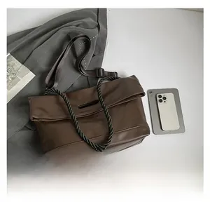 Detail view of coffee brown tote bag with woven handles and adjustable nylon strap