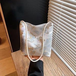 White shoulder bucket bag with elegant blue butterfly embroidery and side tassel detail
