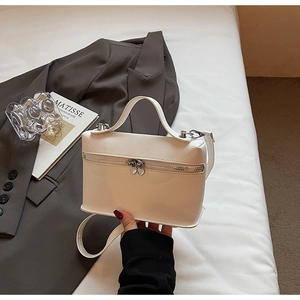 Macro detail of white lychee texture leather handbag with heart-shaped zipper puller