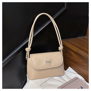 Détail du sac à bandoulière beige en cuir synthétique avec boucle nœud argentée